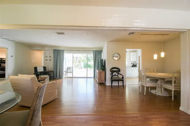 a living room with furniture a dining table and wooden floor