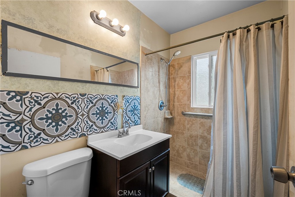 908 West 132nd Street Compton, CA 90222 - Photo 18 of 36 a bathroom with a sink a toilet and a mirror