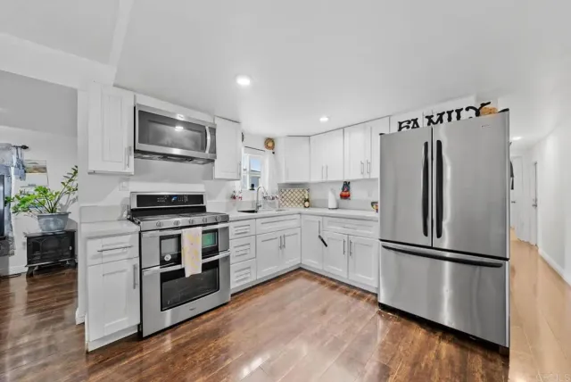 a kitchen with a refrigerator and a stove top oven