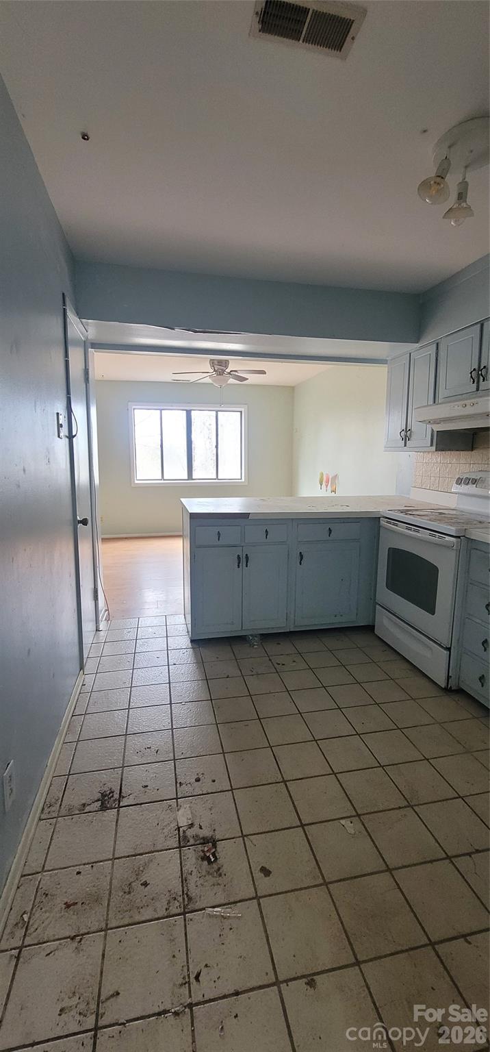 7882 Kinglet Road Connelly Springs, NC 28612 - Photo 12 of 40 a large white kitchen with a stove a sink dishwasher and a refrigerator