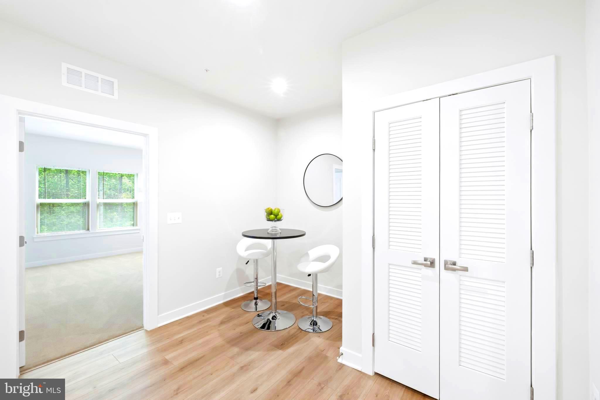 10391 Resort Road, Unit Q Ellicott City, MD 21042 - Photo 9 of 24 a view of a room with wooden floor a glass table and windows