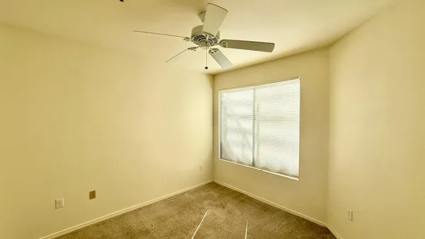 a view of a room with a ceiling fan and a window