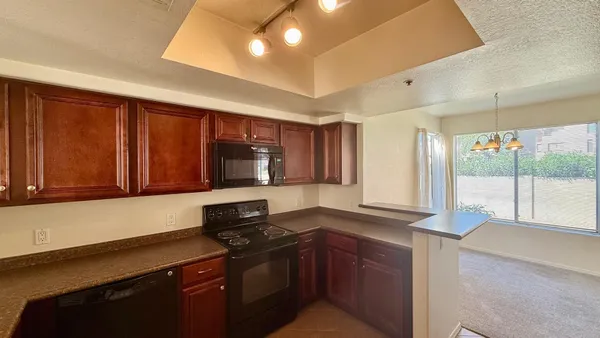 a kitchen with stainless steel appliances granite countertop a stove a sink and a microwave