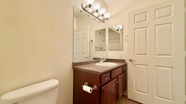 a bathroom with a granite countertop sink a toilet and a mirror