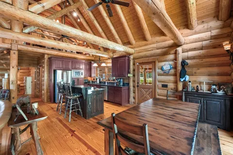 a room with lots of wooden furniture and stainless steel appliances