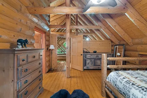 a bedroom with a bed and a wooden floor