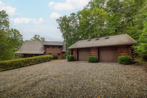 a view of a house with a yard and large tree