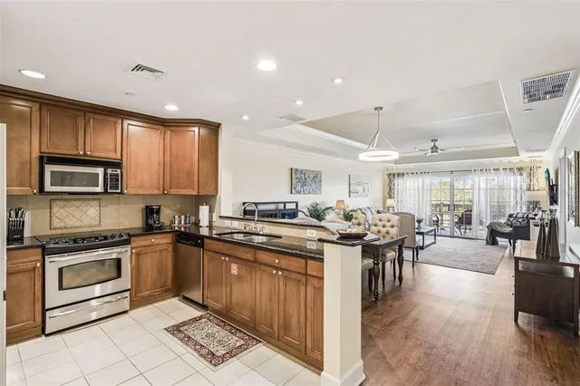 a kitchen with stainless steel appliances granite countertop a sink a stove and a refrigerator