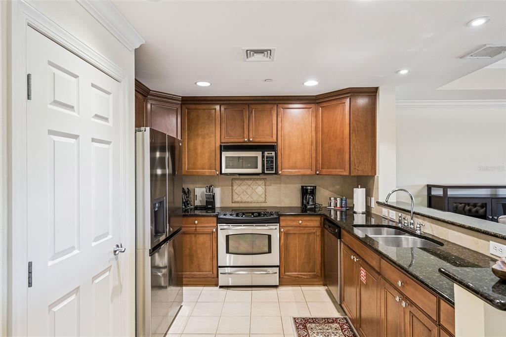 1356 Centre Ct Ridge Drive, Unit 202 Reunion, FL 34747 - Photo 17 of 67 a kitchen with stainless steel appliances granite countertop a stove a sink and a refrigerator