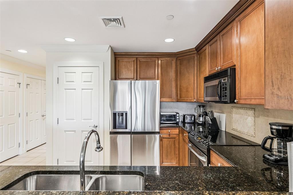 1356 Centre Ct Ridge Drive, Unit 202 Reunion, FL 34747 - Photo 18 of 67 a kitchen with stainless steel appliances granite countertop a sink a stove and a refrigerator