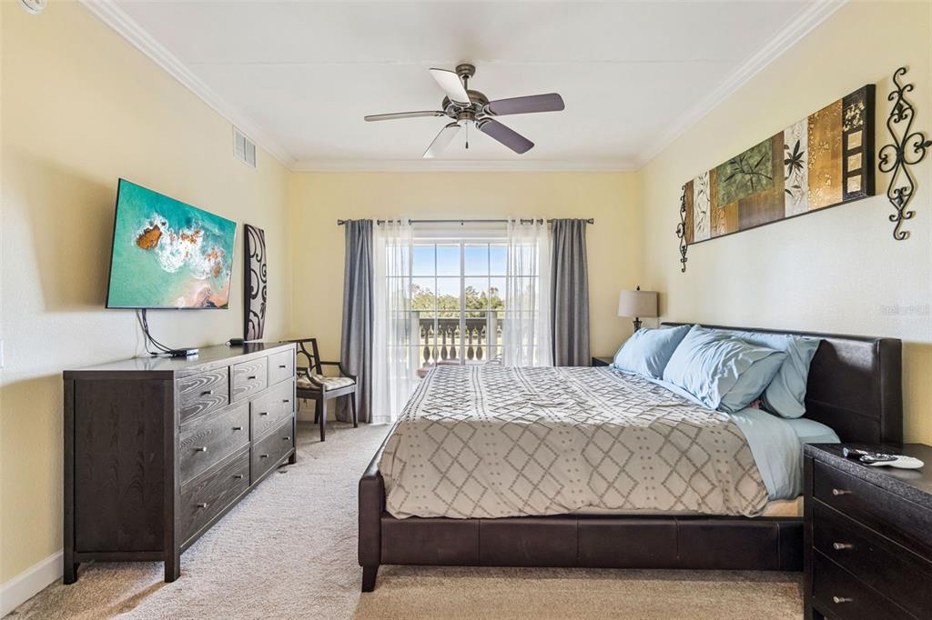 1356 Centre Ct Ridge Drive, Unit 202 Reunion, FL 34747 - Photo 21 of 67 a spacious bedroom with a bed and a flat screen tv