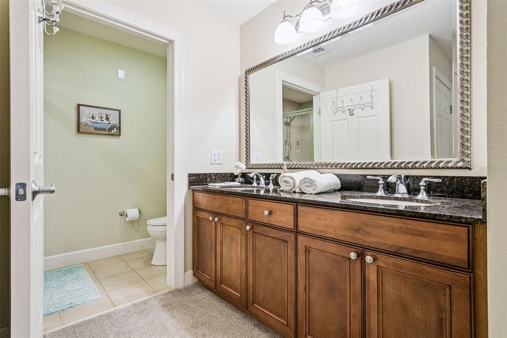 1356 Centre Ct Ridge Drive, Unit 202 Reunion, FL 34747 - Photo 27 of 67 a bathroom with a granite countertop sink a mirror and a toilet