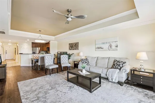 a view of a dining room and livingroom with furniture wooden floor a chandelier