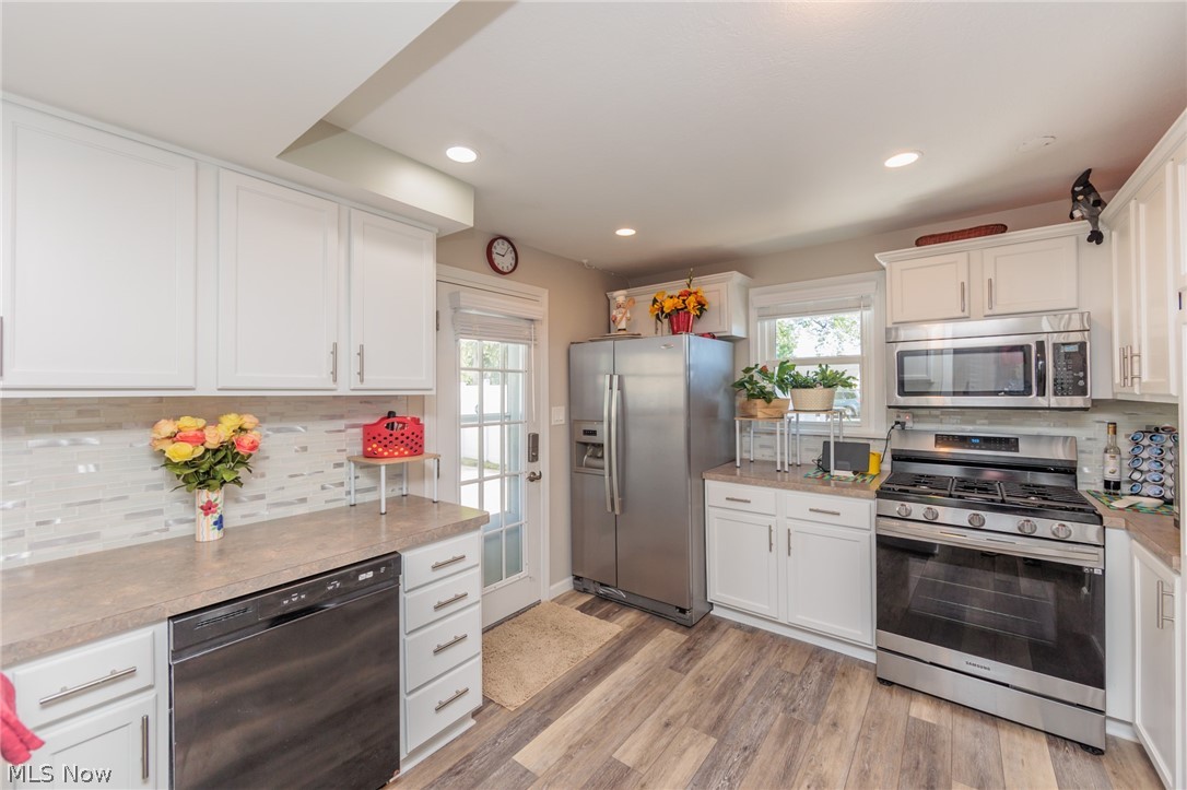 120 Sunset Road Avon Lake, OH 44012 - Photo 8 of 40 Kitchen with light hardwood / wood-style floors, white cabinetry, plenty of natural light, and stainless steel appliances