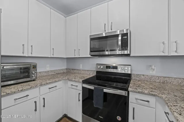 a view of kitchen with dining table chairs and refrigerator