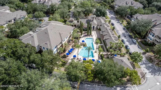 a view of a patio with table and chairs potted plants and floor to ceiling window