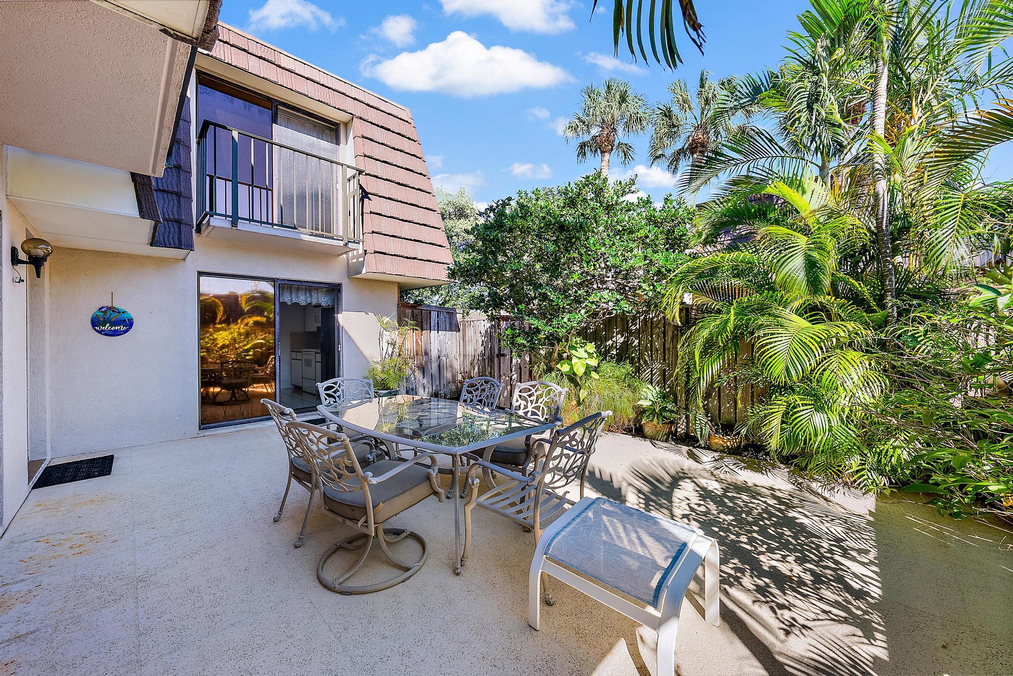 2018 20th Court Jupiter, FL 33477 - Photo 18 of 24 a view of a patio with table and chairs and potted plants