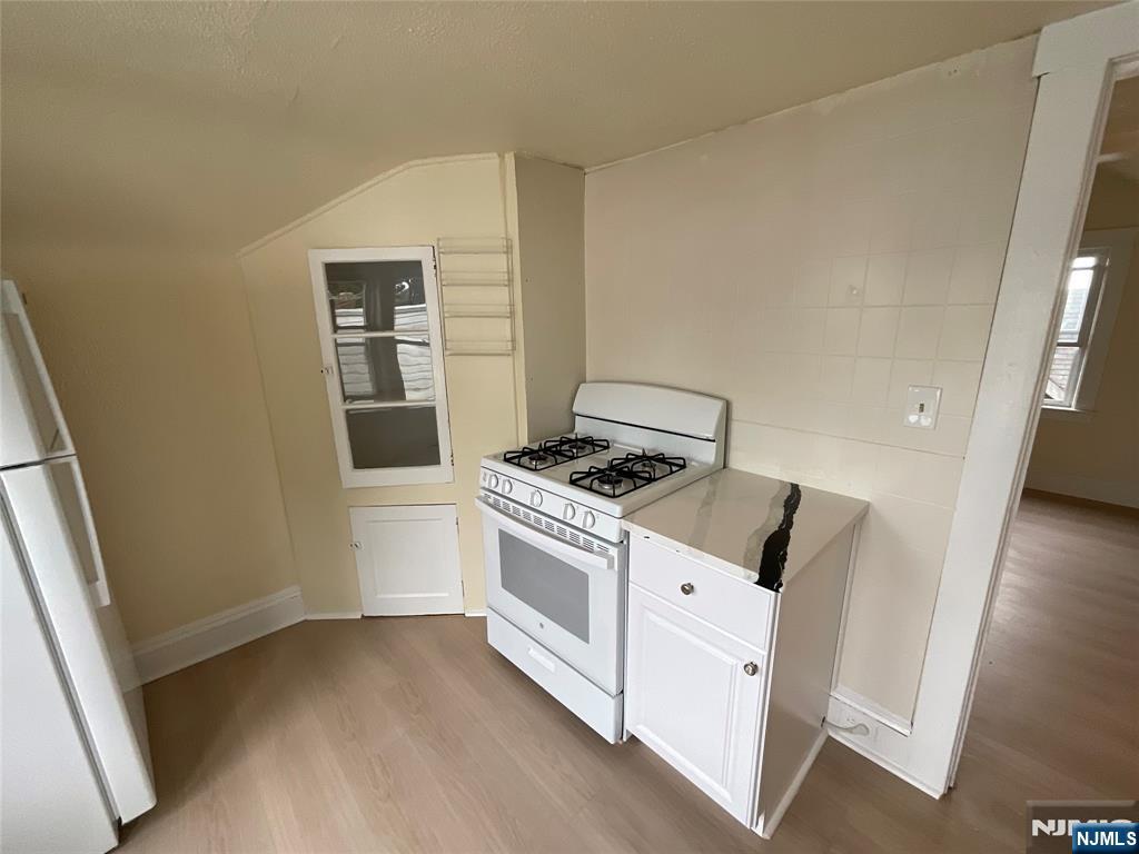 131 Delafield Avenue, Unit 3 Lyndhurst, NJ 07071 - Photo 8 of 15 a view of a kitchen with stove and wooden floor