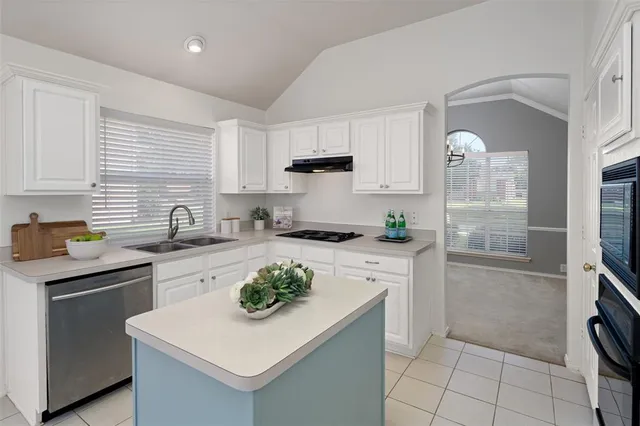 a kitchen with a sink a stove and cabinets