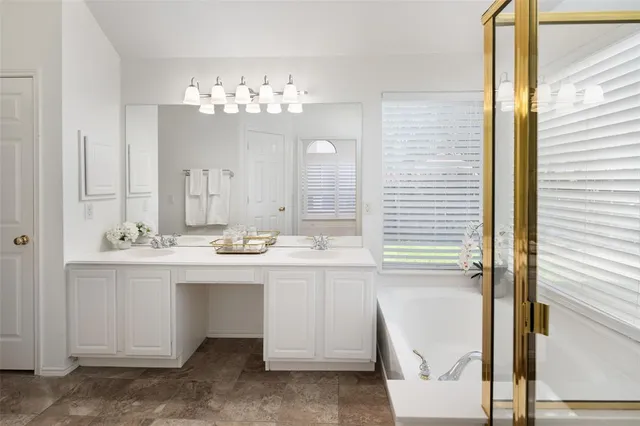 a bathroom with a tub sink and mirror