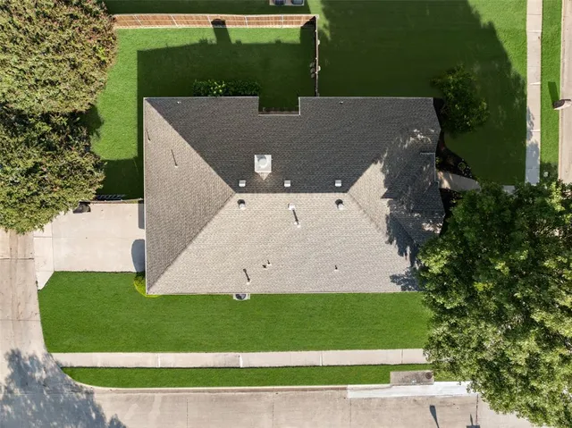 a view of a house with a yard and a large tree