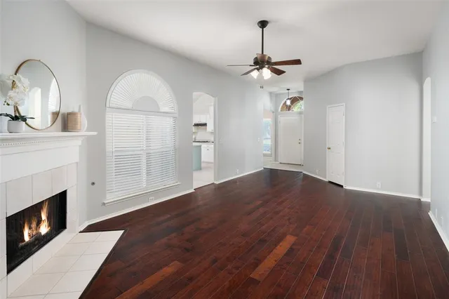 a view of empty room with wooden floor fireplace and a window