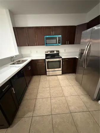 a kitchen with a sink a microwave and refrigerator