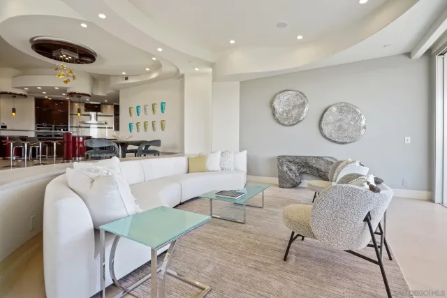 a living room with furniture kitchen view and a mirror