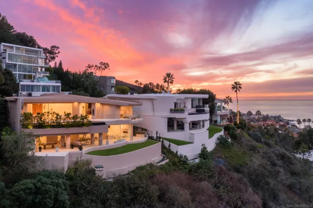 an aerial view of a house with a garden and lake view