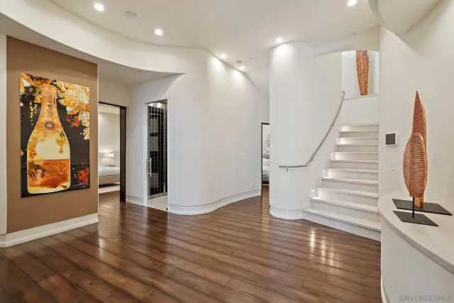 a view of a hallway with wooden floor and door
