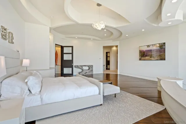 a bedroom with a large bed and a chandelier