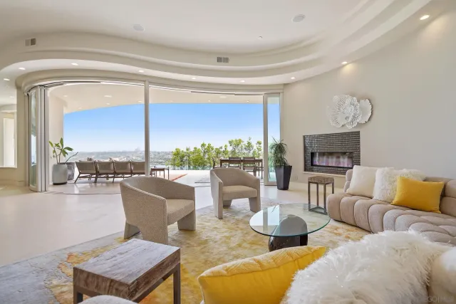 a living room with fireplace furniture and a large window