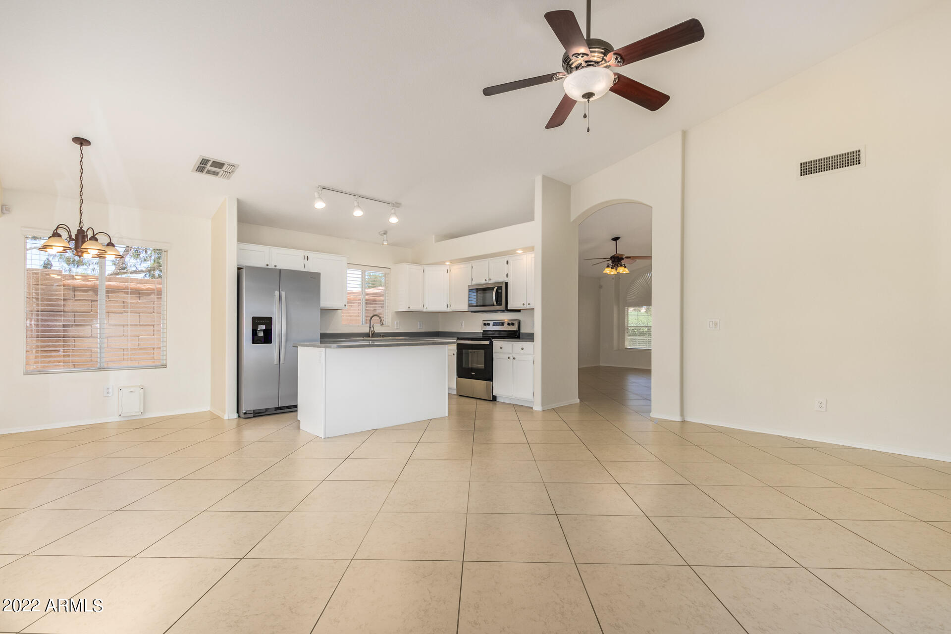 9924 West Burnett Road Peoria, AZ 85382 - Photo 7 of 24 a view of a kitchen with kitchen island white cabinets and stainless steel appliances