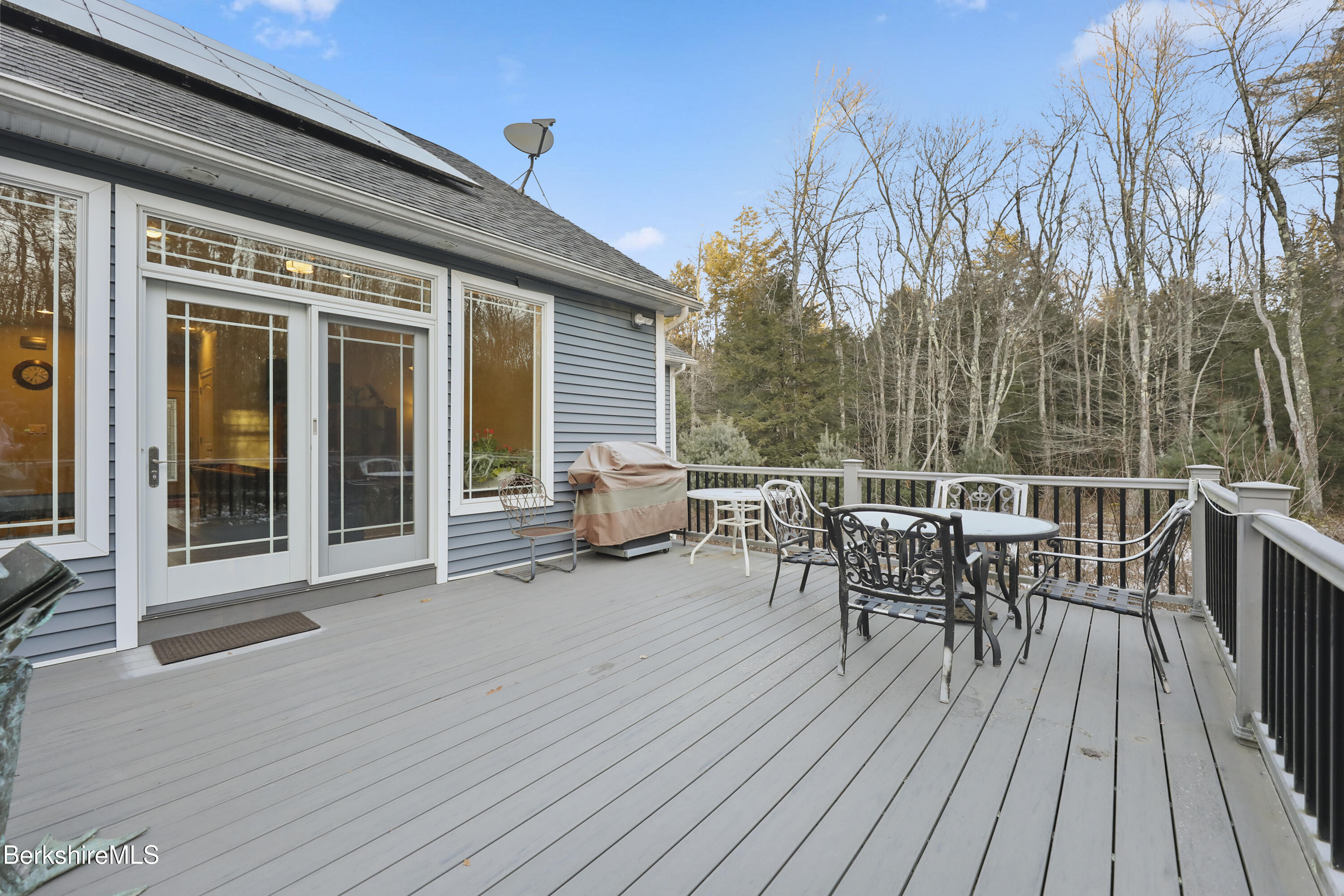 2012 East Otis Road Otis, MA 01029 - Photo 41 of 53 a view of a roof deck with table and chairs floor to ceiling window with wooden floor