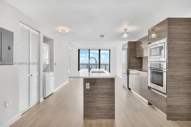 a large white kitchen with a large window