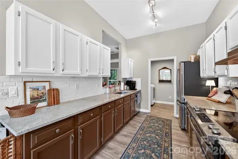 a kitchen with stainless steel appliances granite countertop a sink stove and cabinets