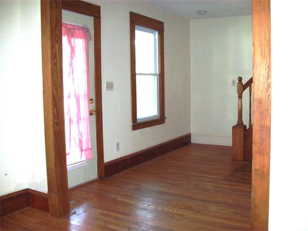 380 Nottingham Street Springfield, MA 01104 - Photo 3 of 18 a view of an empty room with wooden floor and a window
