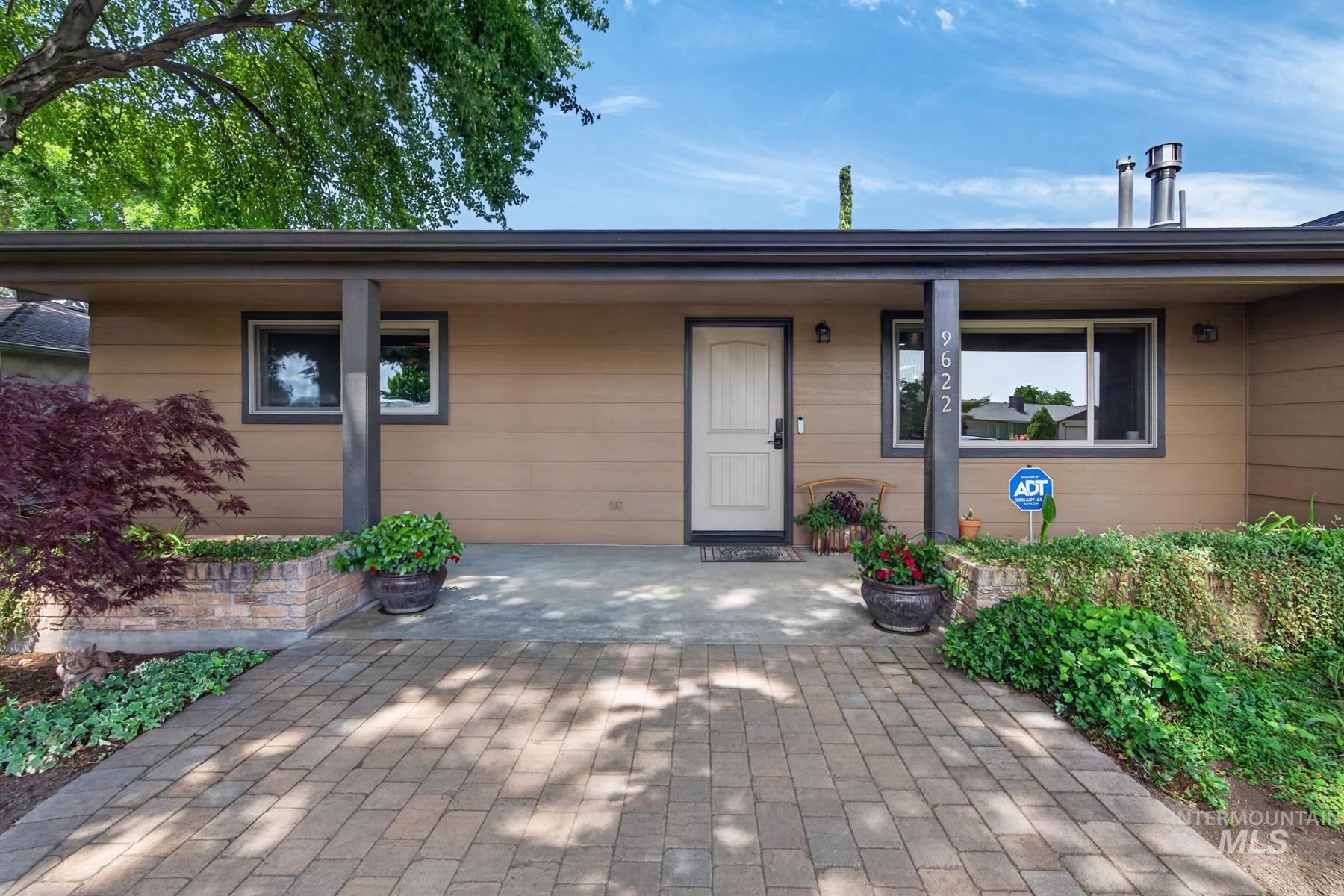 9622 Delaware Street Boise, ID 83709 - Photo 5 of 48 Exterior featuring a covered entryway, paneled front door, and a paver stone walkway