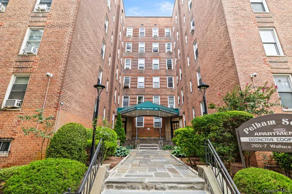 a front view of a multi story residential apartment building with a yard