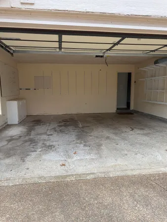 an empty room with wooden floor fireplace and windows