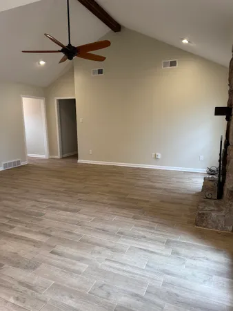 a view of a room with a ceiling fan and a hardwood floor