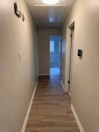 a view of a hallway with wooden floor