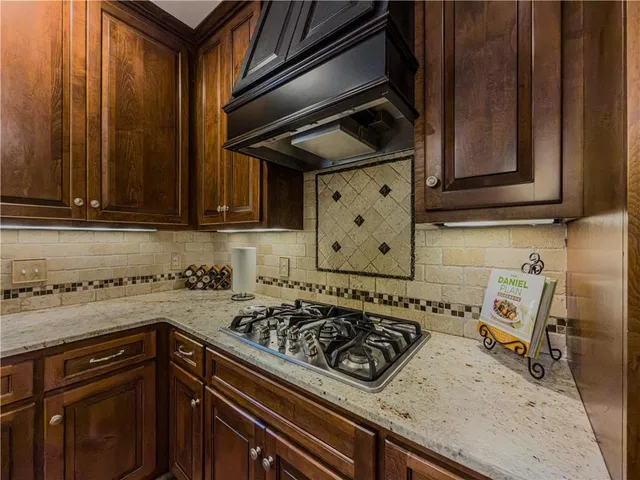 a kitchen with stainless steel appliances granite countertop a sink refrigerator and cabinets