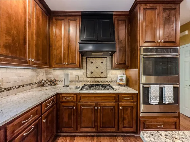 a kitchen with kitchen island granite countertop a sink a counter top space and stainless steel appliances