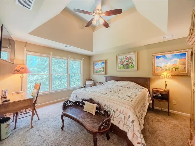 a bedroom with a bed chandelier and a window