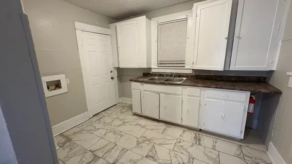 a view of a kitchen with white cabinets