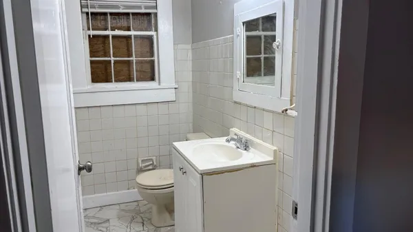 a bathroom with a toilet a sink and a mirror