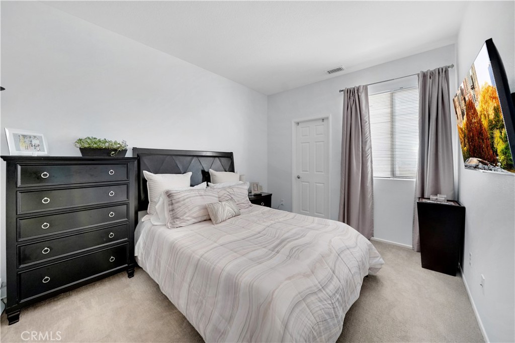 23 Carnation Irvine, CA 92618 - Photo 13 of 30 a bedroom with a bed and a flat tv screen on dresser