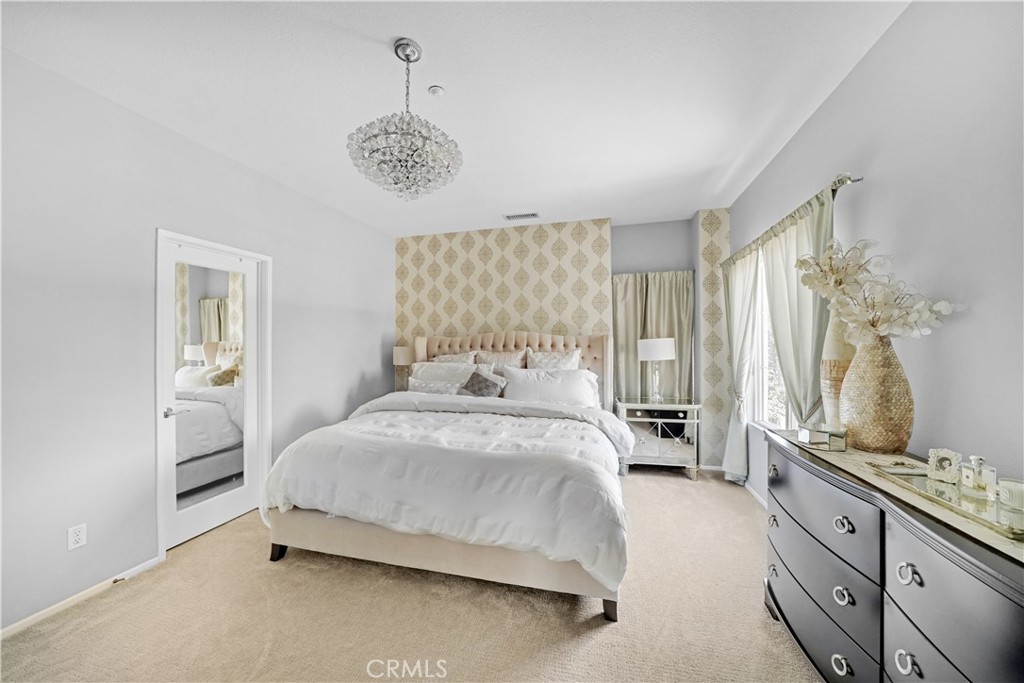 23 Carnation Irvine, CA 92618 - Photo 15 of 30 a bedroom with a bed and a chandelier
