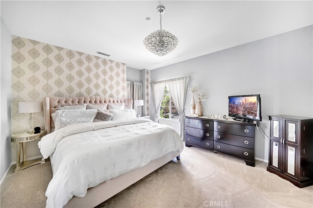 23 Carnation Irvine, CA 92618 - Photo 16 of 30 a spacious bedroom with a bed and a chandelier
